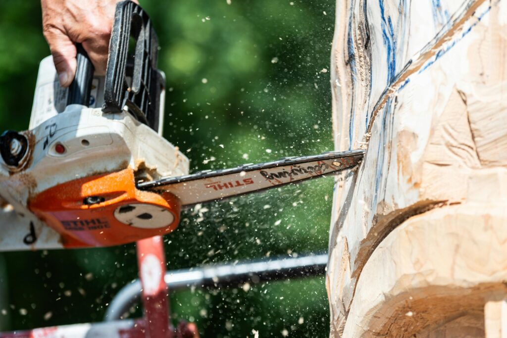 Close-up of chainsaw carving wood sculpture, showcasing power and precision.